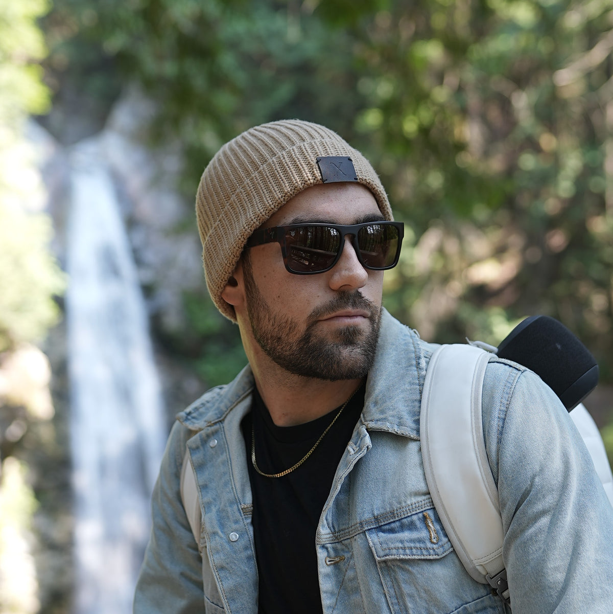man wearing polarized men&#39;s sunglasses, designed by valley rays, with a waterfall in the backgound